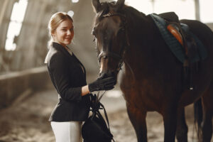 Woman near horse. Rider in a black uniform